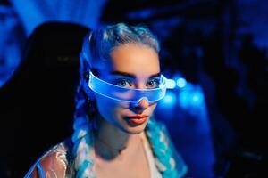 Gamer blogger in neon glasses. Portrait of a young woman in the style of cyberpunk. photo