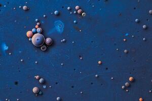 Color drops floating in oil and water over a colorful underground with oil painting effect. photo