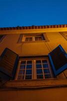 Evening view of a charming building with open shutters in a quaint neighborhood photo