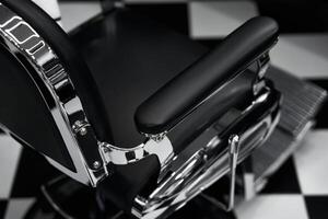 Barber chair in modern salon with black and white checkered floor design photo