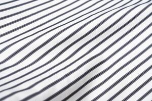 Fabric with alternating black and white stripes displayed on a smooth surface photo