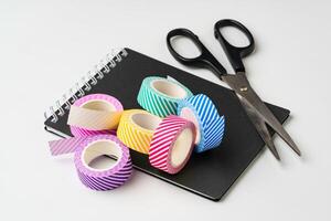 Creative workspace with decorative tape, scissors, and notepad for crafting and planning activities photo