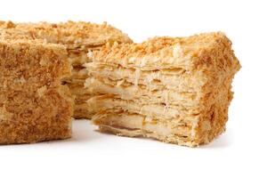 Delicious layered pastry with cream filling and crunchy topping on a white background showcasing its texture photo