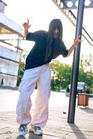 Young dancer performs energetic routine outdoors during golden hour in urban setting photo