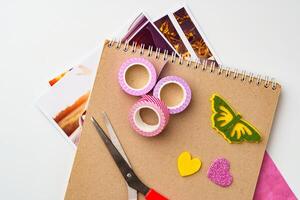 Craft supplies arranged on a table with colorful tape, scissors, and decorative paper cutouts ready for creative projects photo