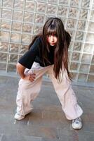 Dancer in urban environment showcases dynamic pose against glass wall photo