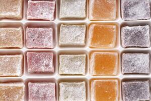 Colorful assortment of traditional confections displayed in a neat grid pattern on a white background photo