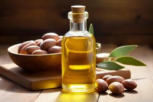 Argan oil in glass bottle with cork lid and argan nuts on wooden table photo