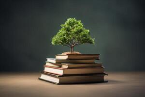 Small tree growing on top of stack of books symbolizing knowledge photo