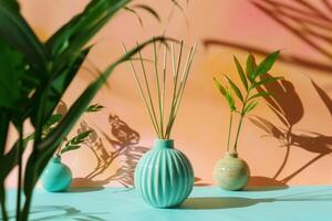 Aromatic reed diffuser standing on blue table with two green plants in vases, creating homey atmosphere photo
