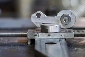 Mechanical part being measured with a caliper in a manufacturing workshop photo