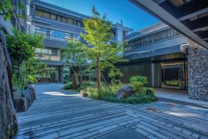 Modern building with green courtyard featuring trees and rocks landscaping photo