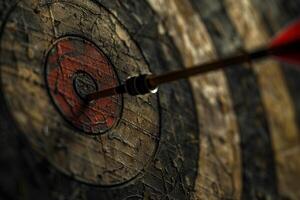 Red arrow hitting the center of an old target on a wooden background photo
