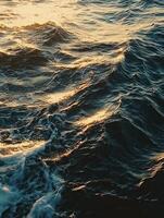 Dramatic rippling ocean waves at sunset reflecting golden light photo