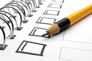 Sharp pencil pointing at blank checklist on spiral notepad photo