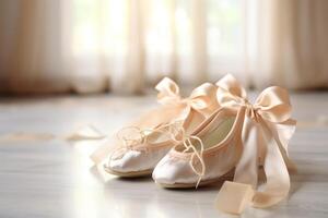 Ballet slippers with silk ribbons resting on floor near window photo