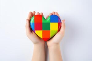 Child hands holding colorful heart puzzle, symbol of autism awareness and neurodiversity support photo