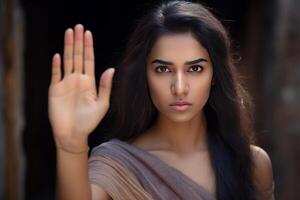 Young woman showing stop sign with hand and serious expression photo