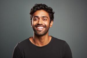 Young indian man smiling and showing teeth on gray background photo