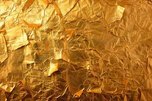 Crumpled gold foil creating a shiny textured background photo