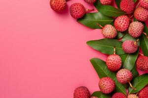 Fresh lychees with green leaves arranged on vibrant pink background photo