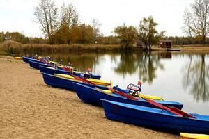 Autumn forest with boat. Reflection of orange and green trees in the lake. photo