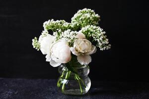 A porcelain teacup and saucer nestle amid bouquets of white blooms, the scene imbued with a gentle light and a quiet sense of beauty photo