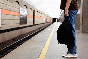 Person waiting in subway, train in motion. photo