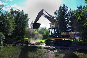 Excavator during earthmoving at open pit on blue sky background On a wonderful day with a positive attitude photo