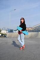 he image portrays a person holding a skateboard, suggesting an active, youthful lifestyle, against an urban backdrop photo
