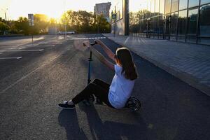 Beautiful and blonde girl practicing long board on the road On a wonderful day with a positive attitude photo