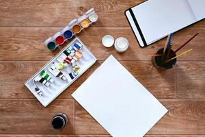 A set of gouache and paints for drawing on a white sheet On a wonderful day with a positive attitude. The concept of creativity and hobbies. photo