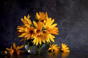 Against a dark canvas, vibrant yellow flowers and scattered petals frame a blank card and envelope, creating a scene of invitation and natural beauty photo