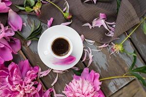 Pink peony flowers and a cup of coffee on a white background. Morninig, spring, fashion composition. Flat lay, top view, copy space. photo