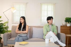 An angry couple sits separately on the sofa, looking away from each other, avoiding a conversation. photo