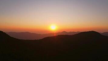 The winter mountains. The setting sun shines down on a serene mountain landscape covered with tropical trees in the evening. video