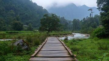 Rustic Wooden Bridge Over a Scenic River. A rustic wooden bridge stretches across a calm river, surrounded by lush greenery and rolling hills. photo