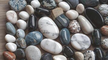 Assorted polished stones in various colors and patterns arranged on a wooden surface for business photo