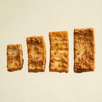 A series of four fried tofu squares increasing in size for culinary business advertising photo