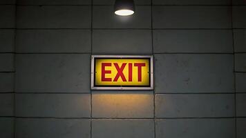 Illuminated Exit Sign on Tile Wall for Business Concepts and Safety Measures photo
