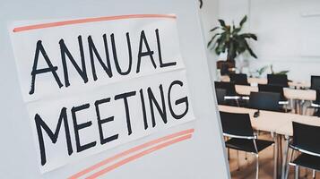 Annual meeting notice on a whiteboard with a conference room in the background for business use photo