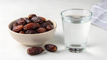 A Still Life of Dates in a Bowl and a Glass of Water for business uses photo
