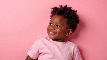 A joyful boy smiles widely while standing in front of a vibrant pink background photo
