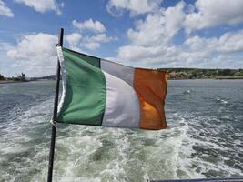 Irish flag waving over river, creative background photo