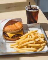 Delicious Cheeseburger and Fries on a Plate in a Cafe photo