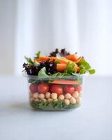 A close-up view of a layered salad in a clear plastic container. photo