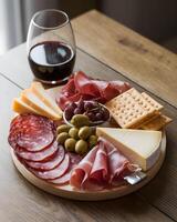 Antipasto plate with cheese, ham, olives and crackers photo