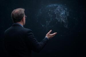 A man in a suit stands under a dark starry sky, gesturing toward a glowing digital Earth, symbolizing technology, global connection, and innovation photo