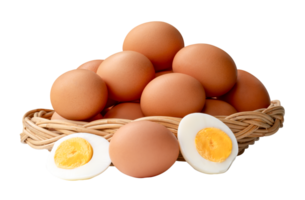 Large group of raw brown chicken eggs and peeled cooked or boiled eggs with egg yolk in two halves in stack in wicker basket isolated with clipping path in file format png
