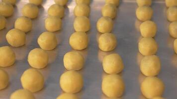 A row of nastar cookies neatly arranged on a baking sheet, ready to be smeared with egg yolk and baked in an oven with sufficient heat. Camera movement video